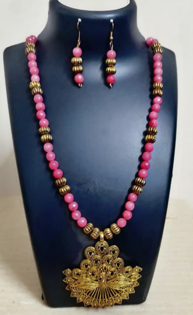 Necklace and earring set — pink and coral with a gold peacock pendant