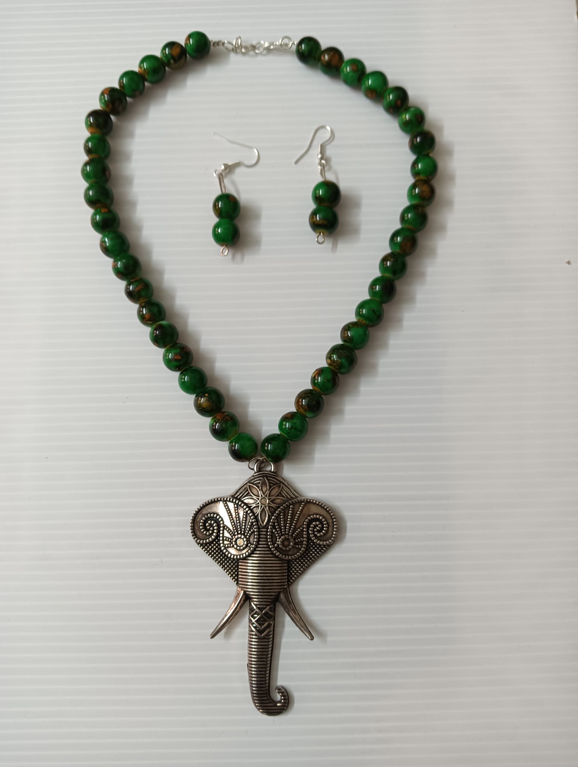 Necklace and earring set — dark green with a brass elephant pendant