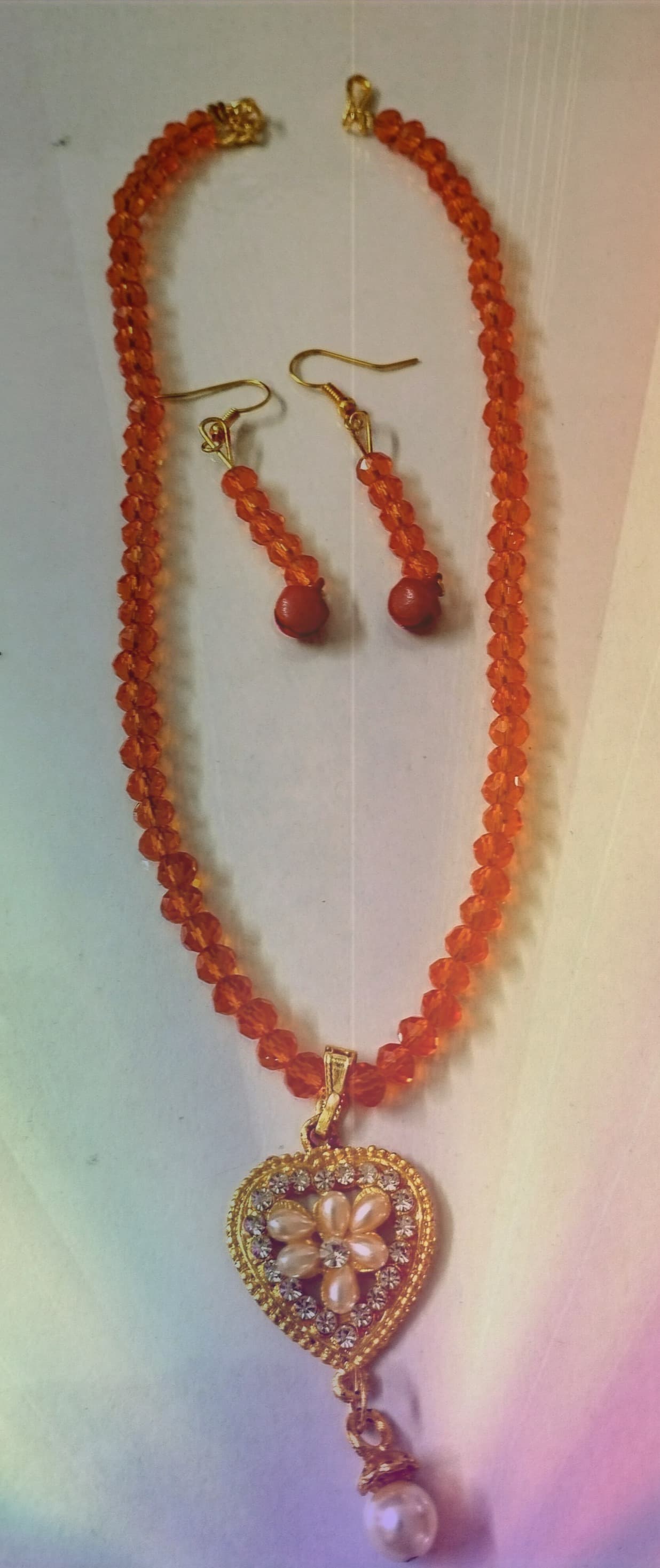 Necklace and earring set — coral orange with a gold pendant