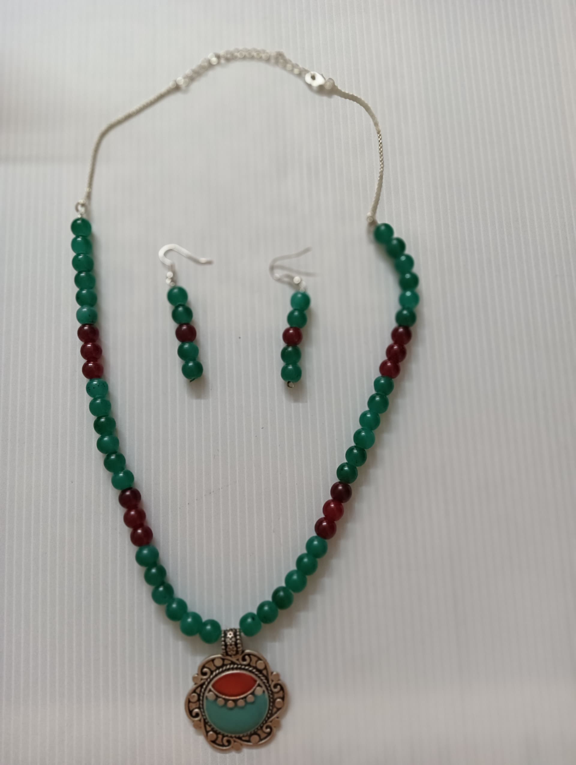 Necklace and earring set — green with a red and brass medallion