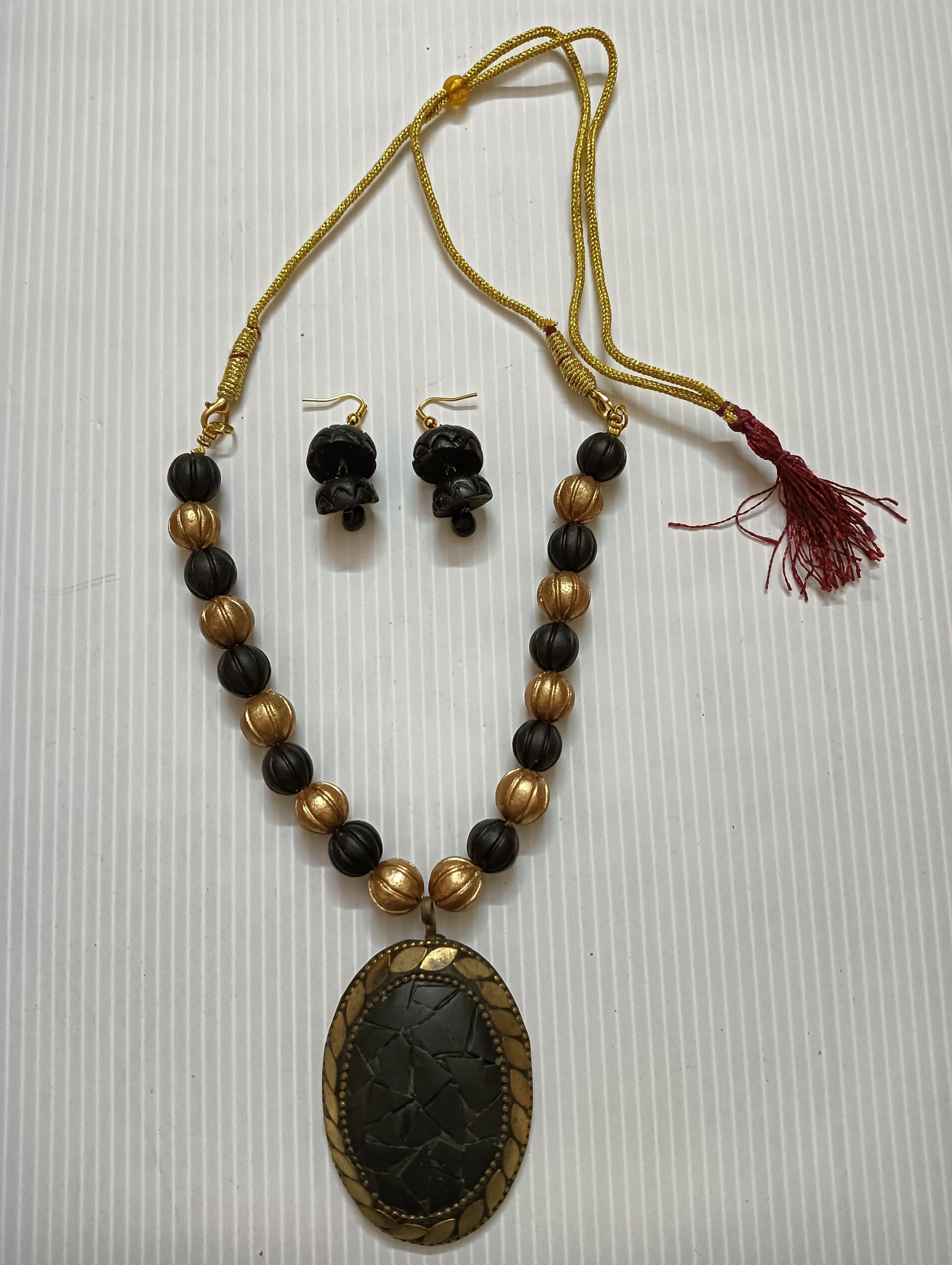Necklace and earring set — black and gold with a dark oval pendant