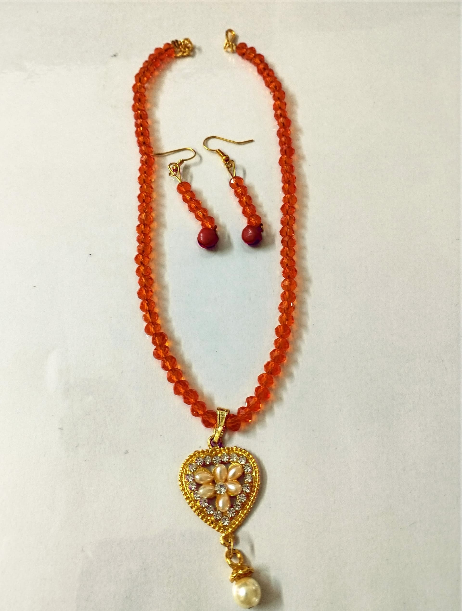 Necklace and earring set — coral orange with a gold heart pendant